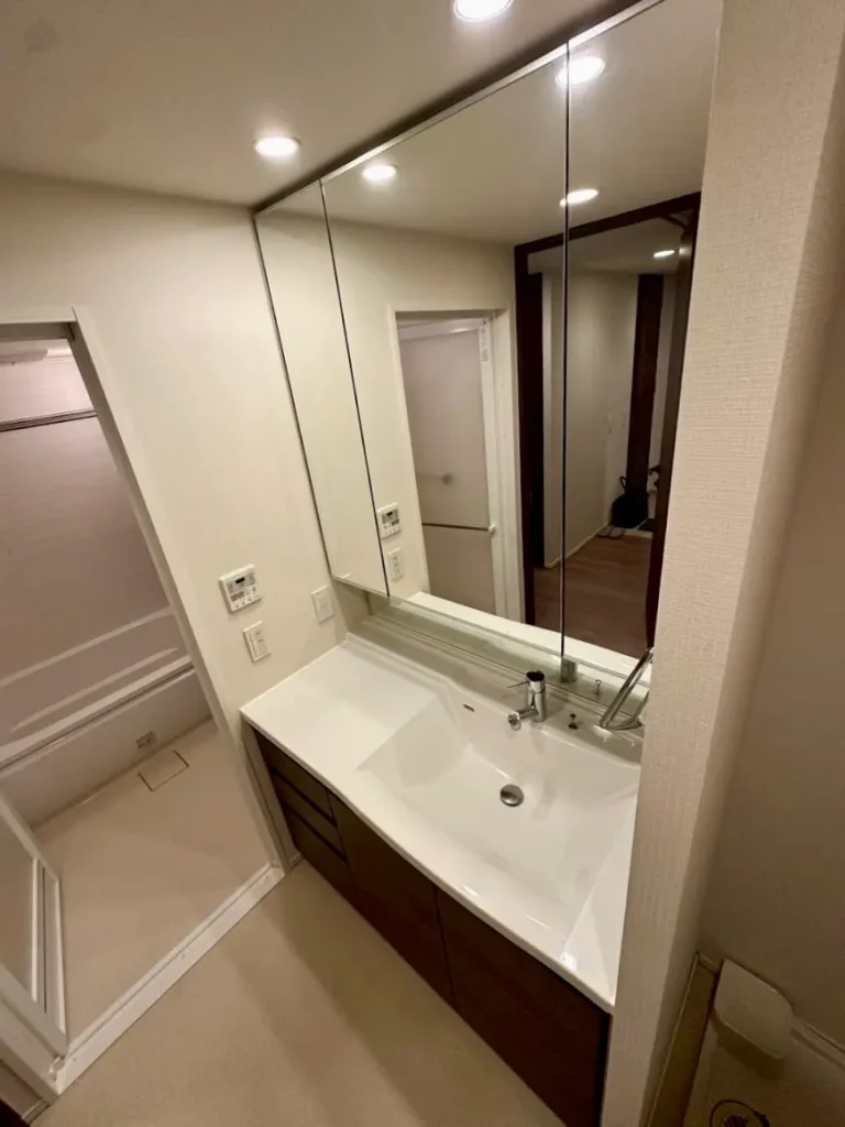 神戸ハーバーランドのタワーマンション洗面所。大きな三面鏡と広いシンクが特徴。