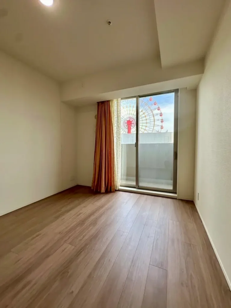 神戸ハーバーランドの観覧車が見えるタワーマンションの居室。バルコニー付きの明るい部屋。
